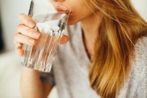 Woman drinking a tall glass of fresh water for daily hydration